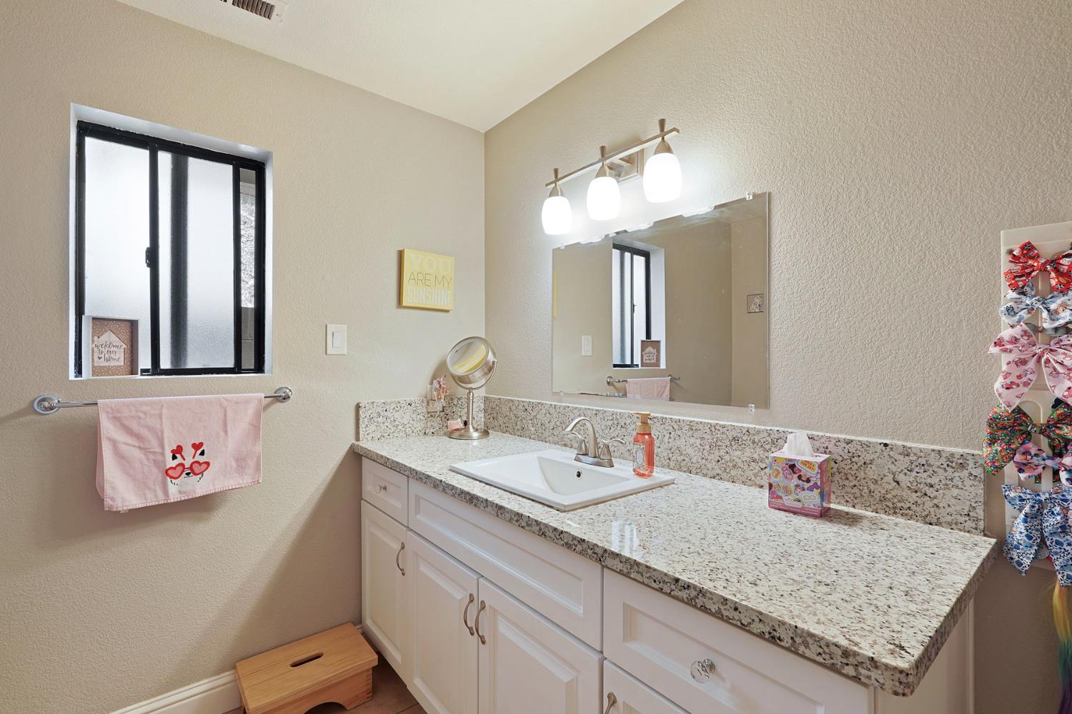 3234 Cambridge Road Cameron Park, CA 95682 - Photo 11 of 42 a bathroom with a granite countertop sink and a mirror