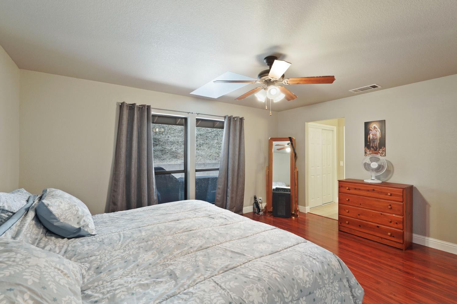 3234 Cambridge Road Cameron Park, CA 95682 - Photo 14 of 42 a bedroom with a large bed and a chandelier