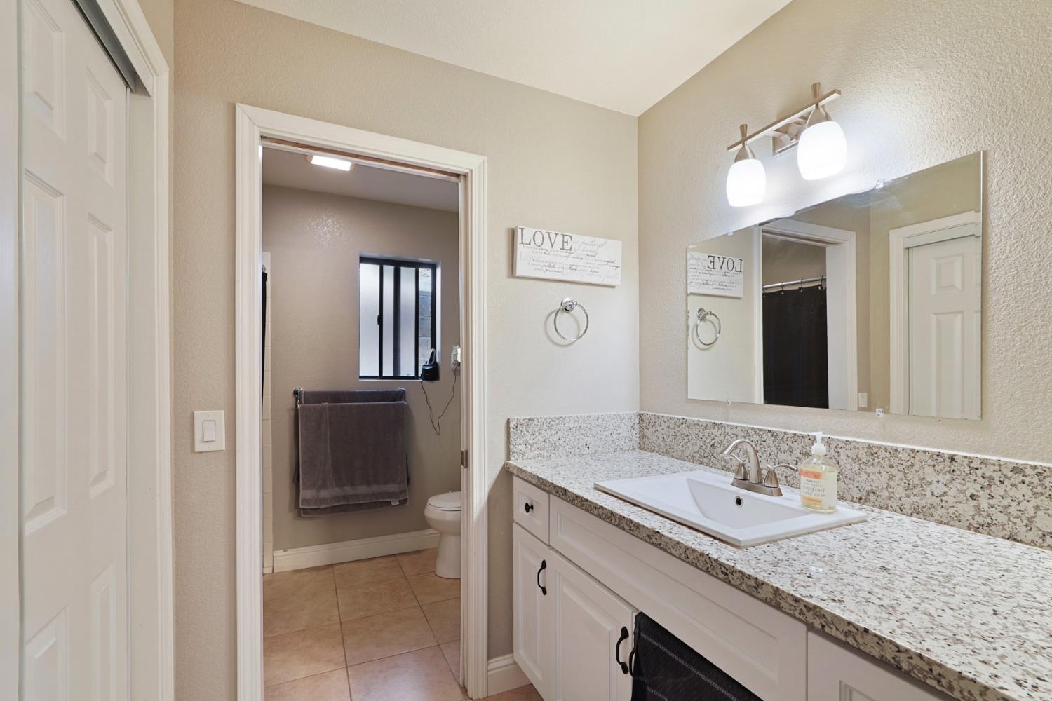 3234 Cambridge Road Cameron Park, CA 95682 - Photo 15 of 42 a bathroom with a granite countertop sink double and mirror