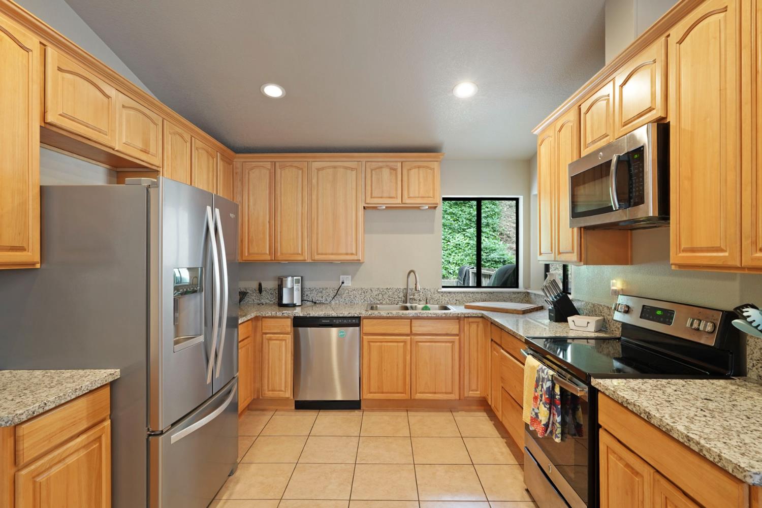 3234 Cambridge Road Cameron Park, CA 95682 - Photo 18 of 42 a kitchen with stainless steel appliances granite countertop a sink stove refrigerator and cabinets