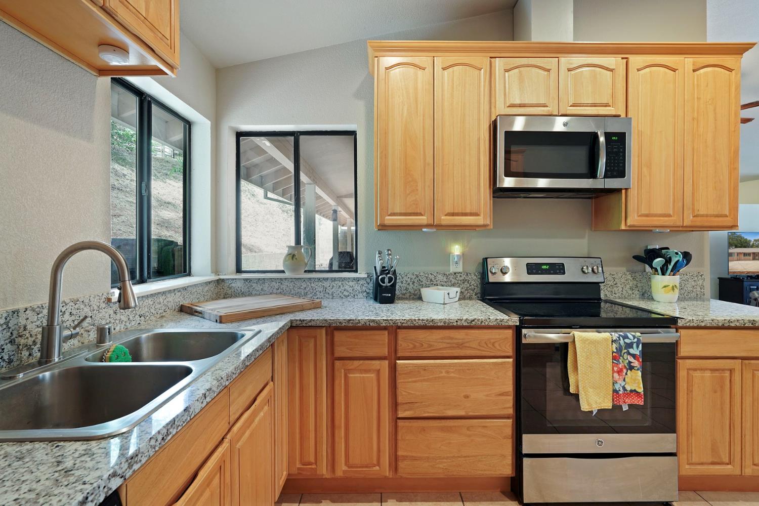 3234 Cambridge Road Cameron Park, CA 95682 - Photo 21 of 42 a kitchen with stainless steel appliances granite countertop a sink stove and microwave