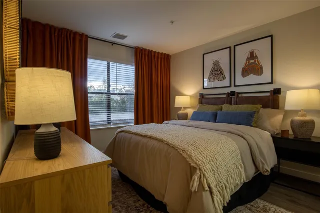 a bedroom with a bed and dresser with mirror