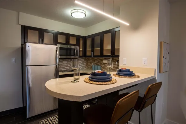 a kitchen with a sink a refrigerator and cabinets