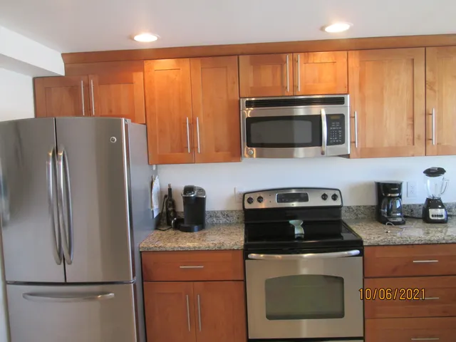 a kitchen with granite countertop a refrigerator stove and microwave