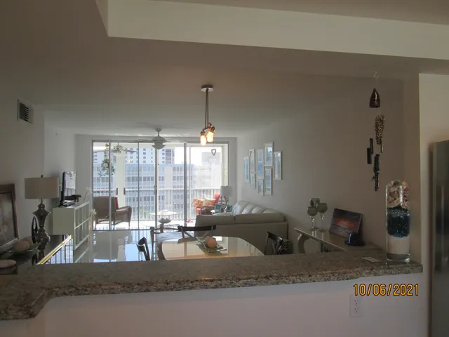 a kitchen with a granite countertop sink and a large mirror