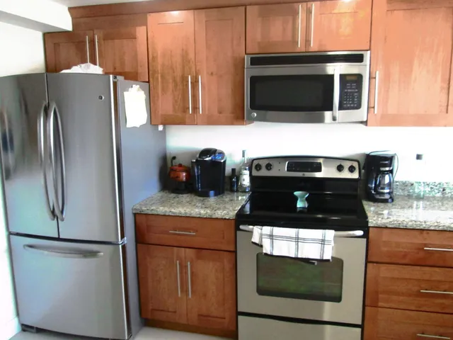 a kitchen with granite countertop a refrigerator stove and microwave