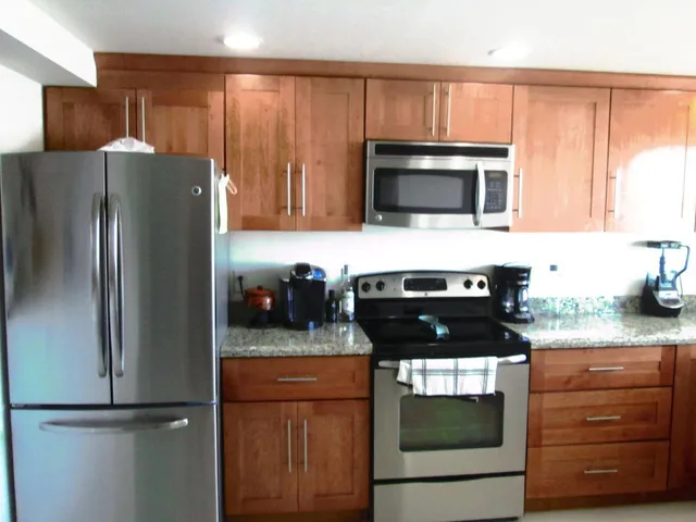 a kitchen with granite countertop stainless steel appliances and wooden cabinets