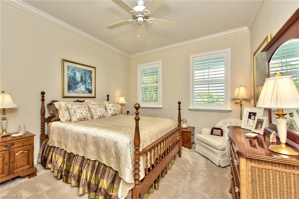 6922 Avalon Circle, Unit 206 Naples, FL 34112 - Photo 20 of 32 a spacious bedroom with a bed and a chandelier