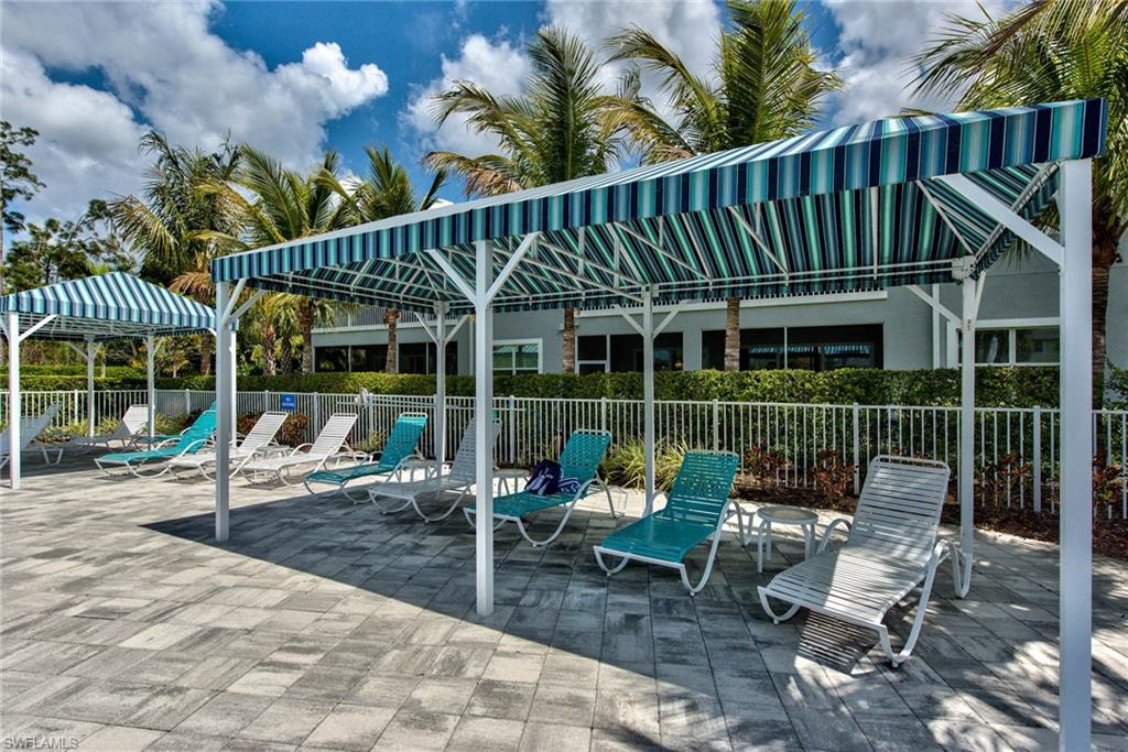 6922 Avalon Circle, Unit 206 Naples, FL 34112 - Photo 28 of 32 a backyard of a house with table and chairs