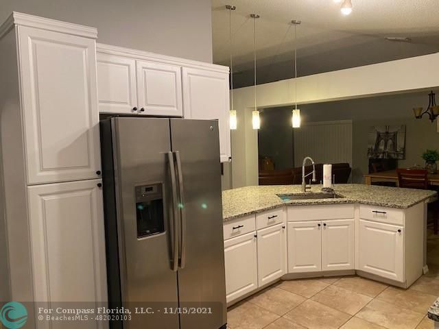 2147 Marisol Loop Kissimmee, FL 34743 - Photo 11 of 20 a kitchen with stainless steel appliances a refrigerator sink and cabinets