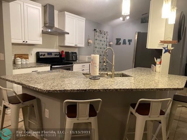 2147 Marisol Loop Kissimmee, FL 34743 - Photo 13 of 20 a kitchen with granite countertop kitchen island stainless steel appliances a stove a sink and a counter