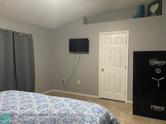 2147 Marisol Loop Kissimmee, FL 34743 - Photo 17 of 20 a bedroom with a bed and a flat screen tv