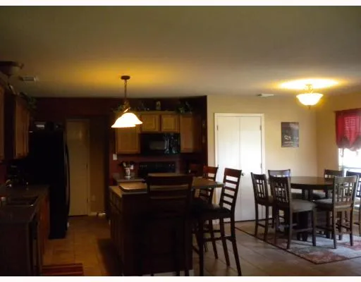 a kitchen with a dining table chairs and refrigerator