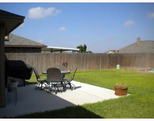 a view of backyard with seating area and green space