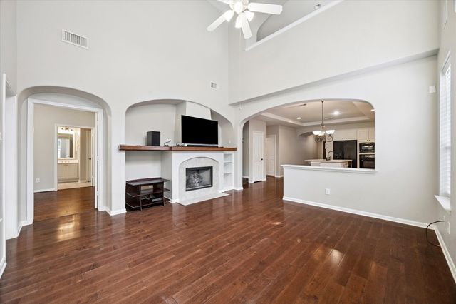a view of a livingroom with a flat screen tv wooden floor and a fireplace