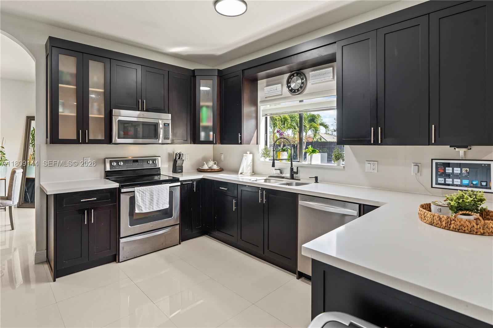 3801 Southwest 149th Avenue Miami, FL 33185 - Photo 13 of 41 a kitchen with a stove a sink and a microwave
