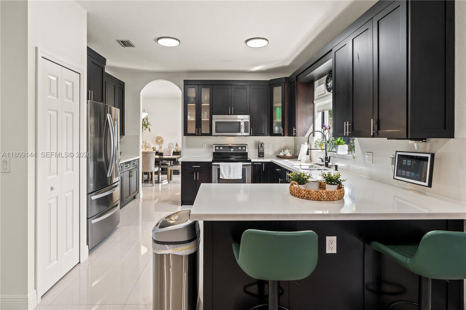 3801 Southwest 149th Avenue Miami, FL 33185 - Photo 14 of 41 a kitchen with a table chairs sink and microwave
