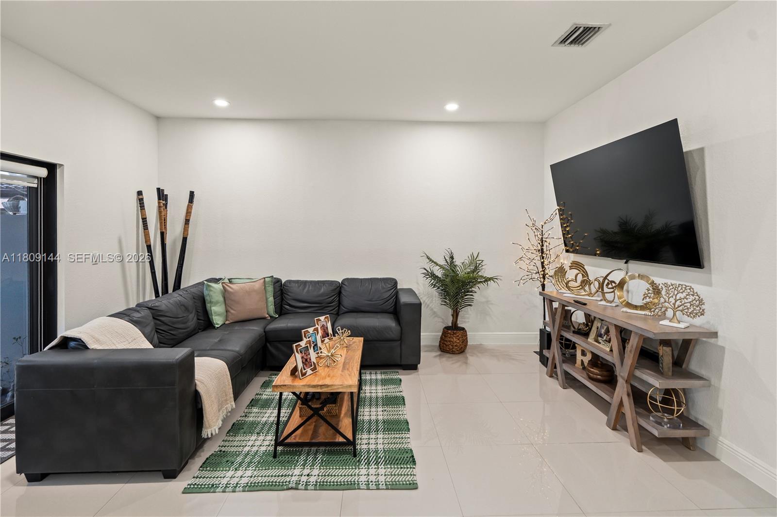 3801 Southwest 149th Avenue Miami, FL 33185 - Photo 16 of 41 a living room with furniture and a flat screen tv