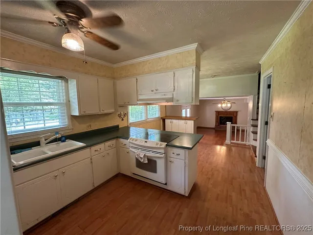 a kitchen with stainless steel appliances sink stove top oven and cabinets