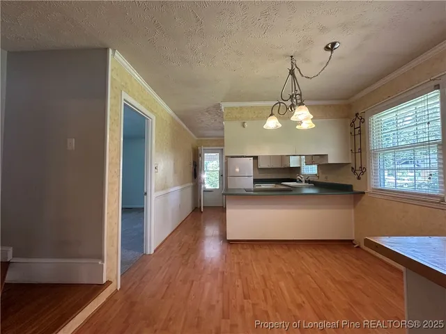 a view of a living room and kitchen with wooden floor