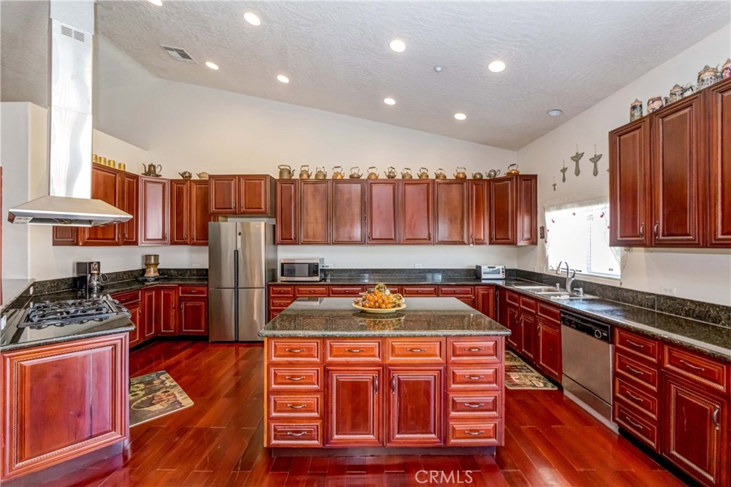 3789 Luna Road Phelan, CA 92371 - Photo 24 of 67 a kitchen with stainless steel appliances granite countertop a sink stove and refrigerator