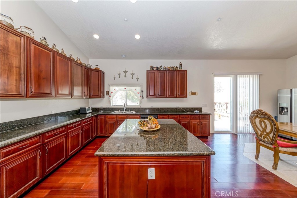 3789 Luna Road Phelan, CA 92371 - Photo 26 of 67 a kitchen with granite countertop kitchen island granite countertop wooden cabinets granite counter tops and a stove