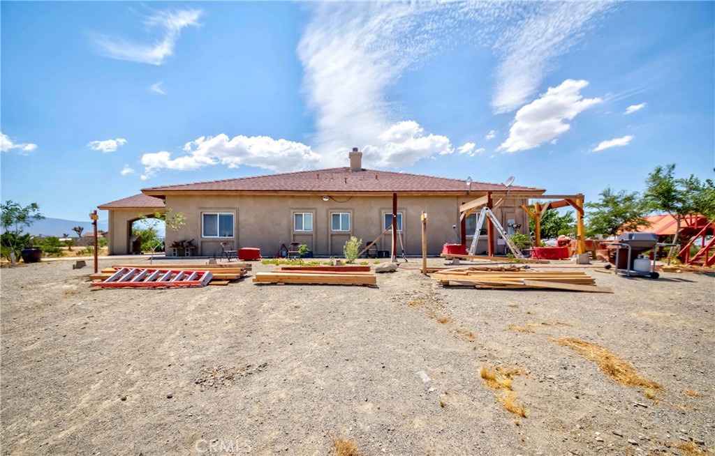 3789 Luna Road Phelan, CA 92371 - Photo 57 of 67 a view of the patio with dining table and chairs under an umbrella