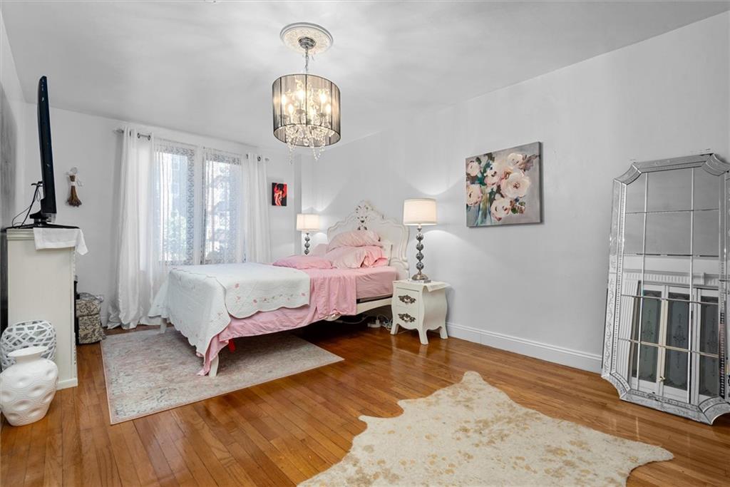 7401 Shore Road, Unit 1E Brooklyn, NY 11209 - Photo 18 of 21 a bedroom with a bed dresser and wooden floor