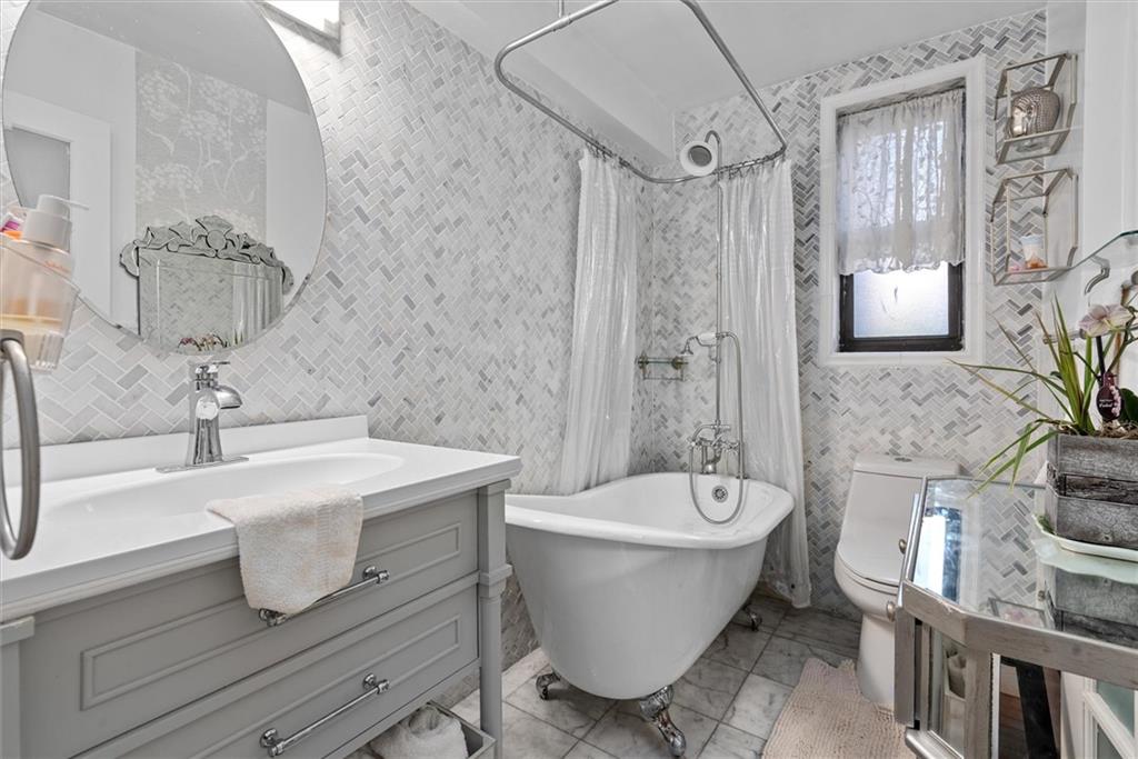 7401 Shore Road, Unit 1E Brooklyn, NY 11209 - Photo 21 of 21 a bathroom with a bathtub a sink and a mirror