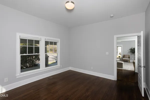 a view of a livingroom with wooden floor and a large window