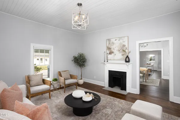 a living room with furniture a fireplace and a chandelier