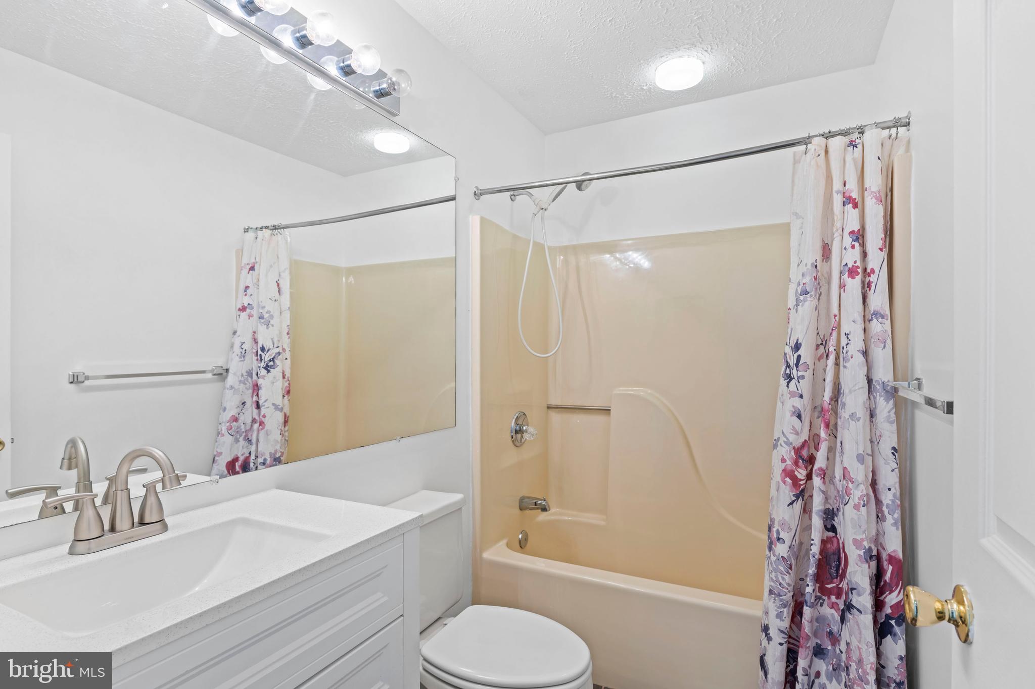 31 Beagle Run, Unit 88 Nottingham, MD 21236 - Photo 24 of 43 a bathroom with a shower curtain a sink and a large mirror