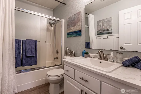a bathroom with a sink a toilet and shower