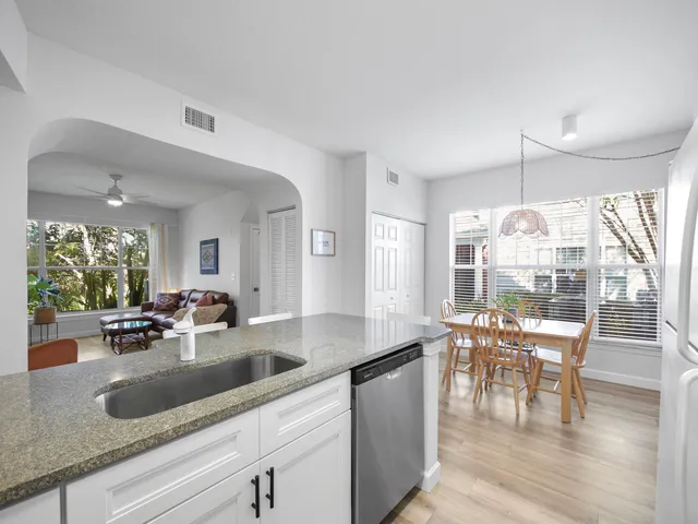 a kitchen with granite countertop a table and chairs in it