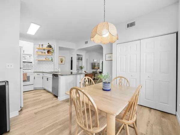 a kitchen with stainless steel appliances granite countertop a kitchen island a stove a sink a dining table and chairs