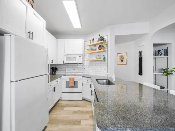a kitchen with white cabinets and white appliances