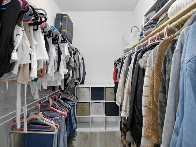 a view of walk in closet with clothes and shoes