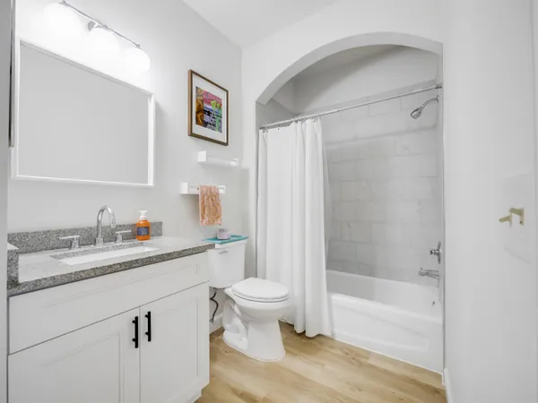 a bathroom with a granite countertop sink a toilet and a shower