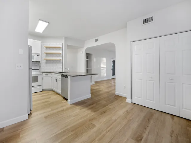 a view of kitchen with wooden floor and electronic appliances