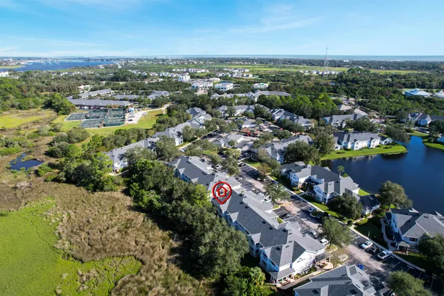 an aerial view of a city with lots of residential buildings ocean and mountain view in back