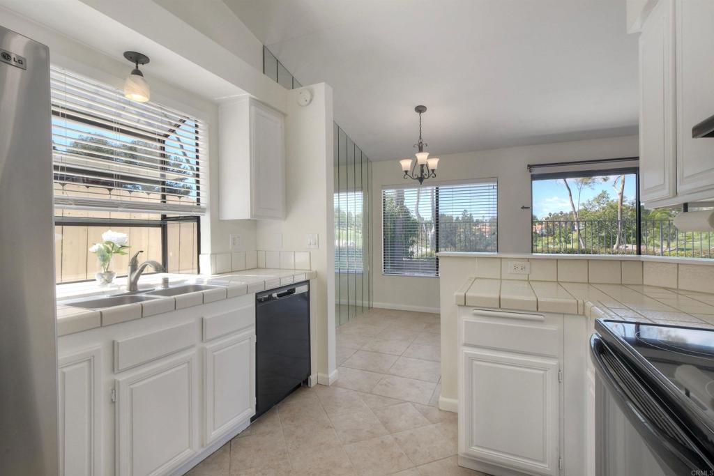 1394 Longfellow Road Vista, CA 92081 - Photo 20 of 50 a kitchen with kitchen island a sink appliances cabinets and a large window