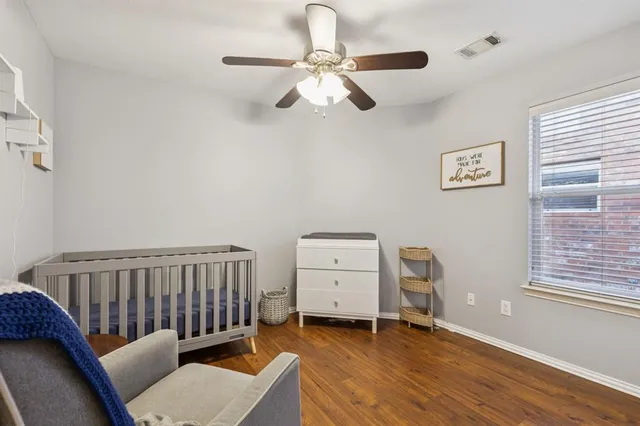 a bedroom with a baby bed a couch and a window