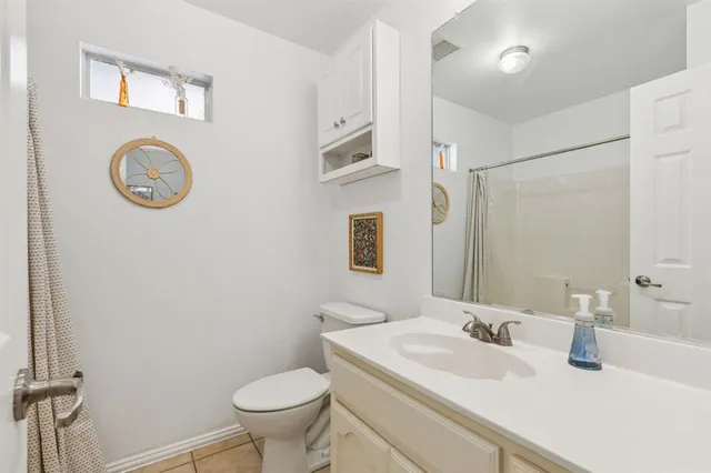 a bathroom with a granite countertop toilet sink and mirror