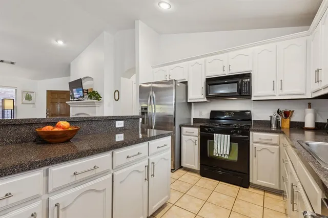 a kitchen with stainless steel appliances granite countertop a sink a stove and cabinets