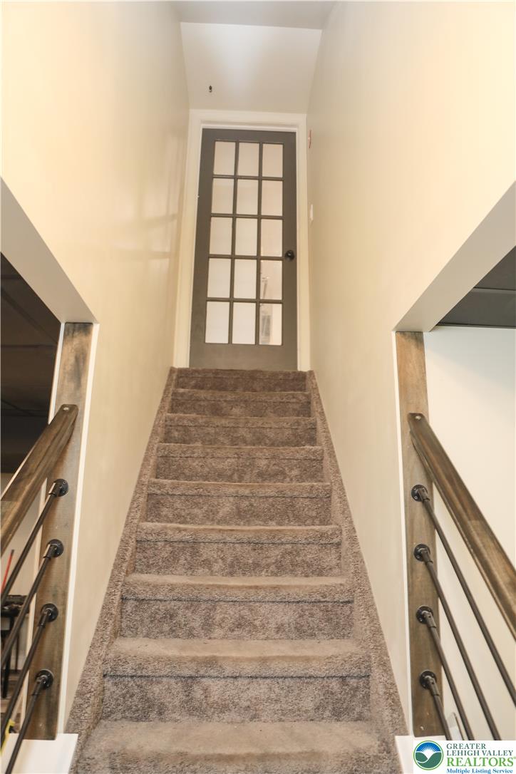 1412 Stanford Road Bethlehem, PA 18018 - Photo 45 of 58 Ascend carpeted stairs to a classic glass-paned door, revealing functional and adaptable living spaces.