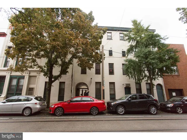 a white car parked in front of a white house
