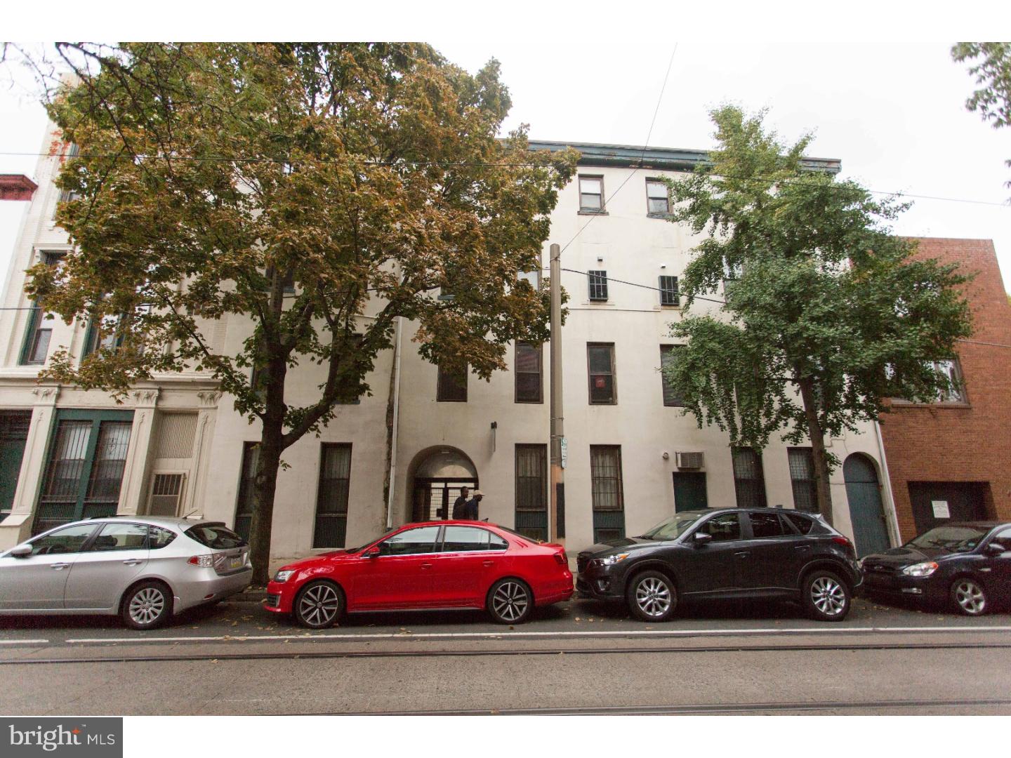 a white car parked in front of a white house
