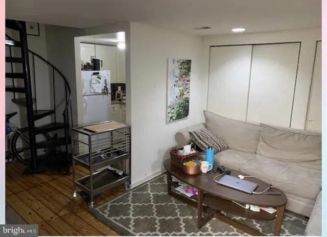 a living room with furniture a rug and wooden floor