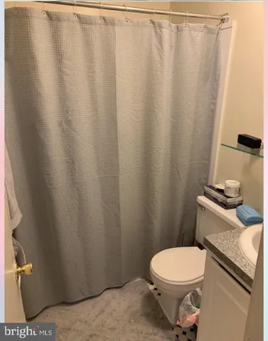 a white toilet sitting next to a shower curtain
