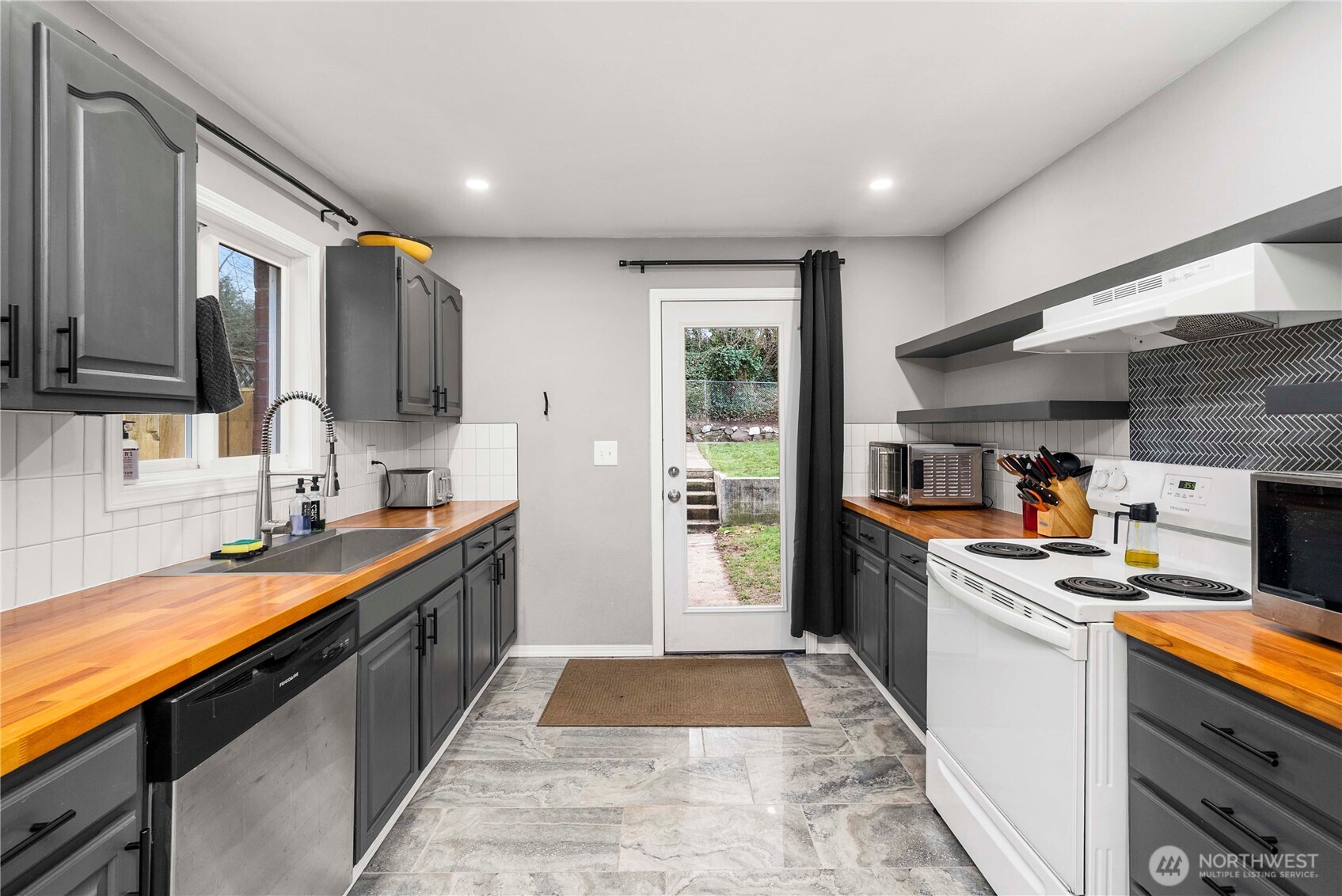 3608 South L Street Tacoma, WA 98418 - Photo 5 of 40 a kitchen with stainless steel appliances granite countertop a sink stove and refrigerator